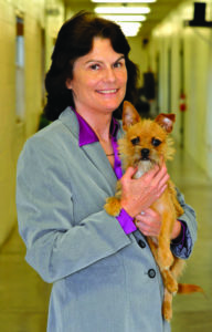 Photo of Kim Staton, Director of Osceola County Animal Services holding small dog.